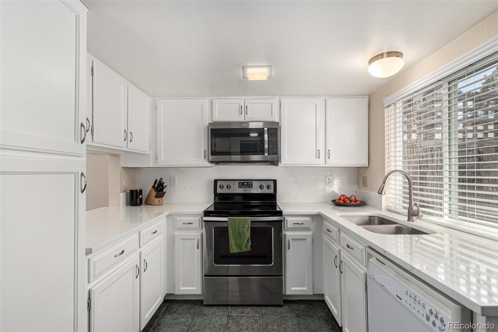 3657 South Laredo Street, Unit E Aurora, CO 80013 - Photo 3 of 20 a kitchen with white cabinets and appliances