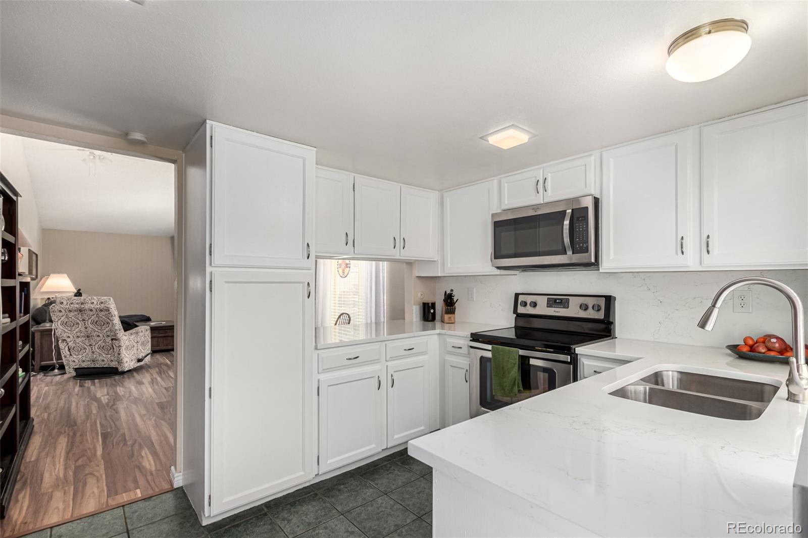 3657 South Laredo Street, Unit E Aurora, CO 80013 - Photo 4 of 20 a kitchen with a sink a stove and cabinets