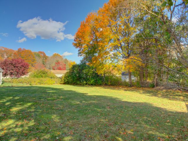 a view of a field with an trees in the background