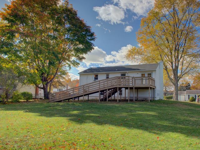 a view of a house with a big yard and large trees