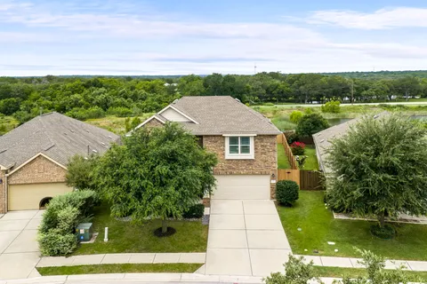 a view of a house with a yard and potted plants
