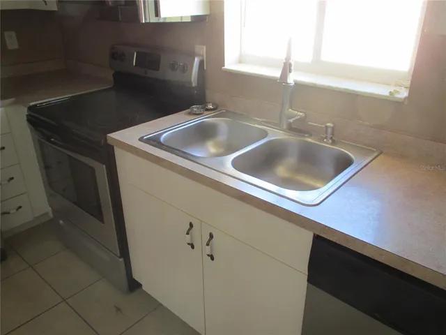 a kitchen with a refrigerator and a stove top oven
