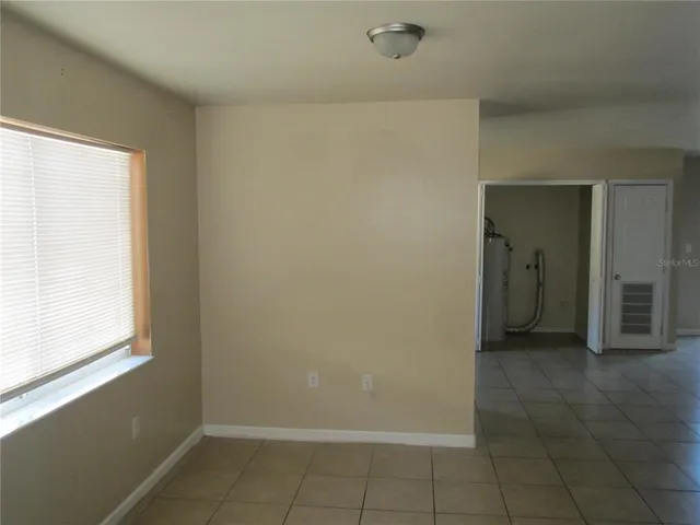 a view of an empty room with closet and a window