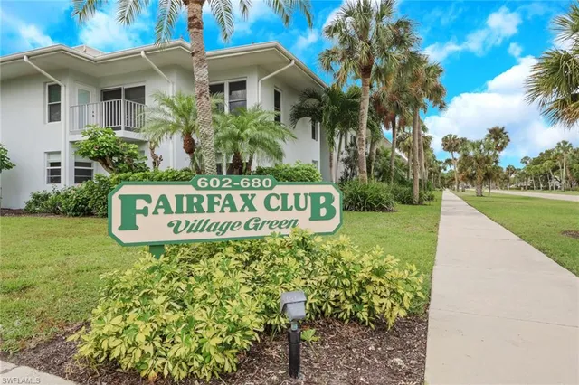 a sign of golf club on a wall under a blue tree