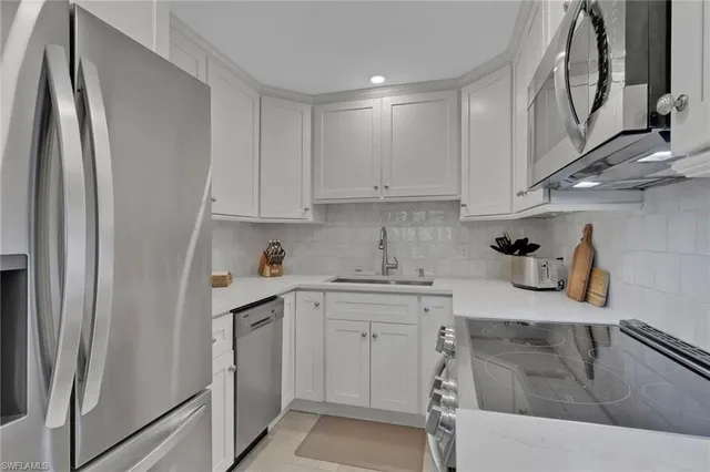 a kitchen with stainless steel appliances granite countertop a sink refrigerator and cabinets