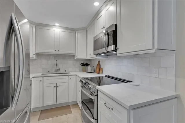 a kitchen with stainless steel appliances white cabinets and a sink