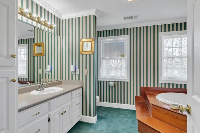 a bathroom with a tub a sink and a mirror