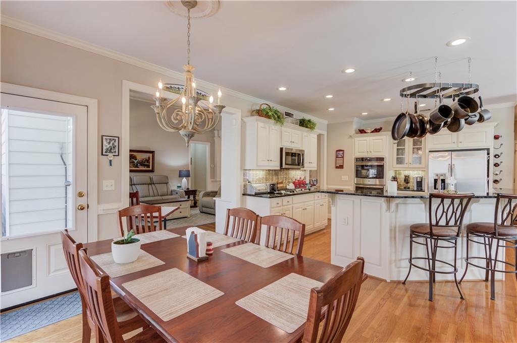 8012 Cypress Point Monroe, GA 30656 - Photo 18 of 67 a view of a dining room and livingroom with furniture wooden floor a chandelier