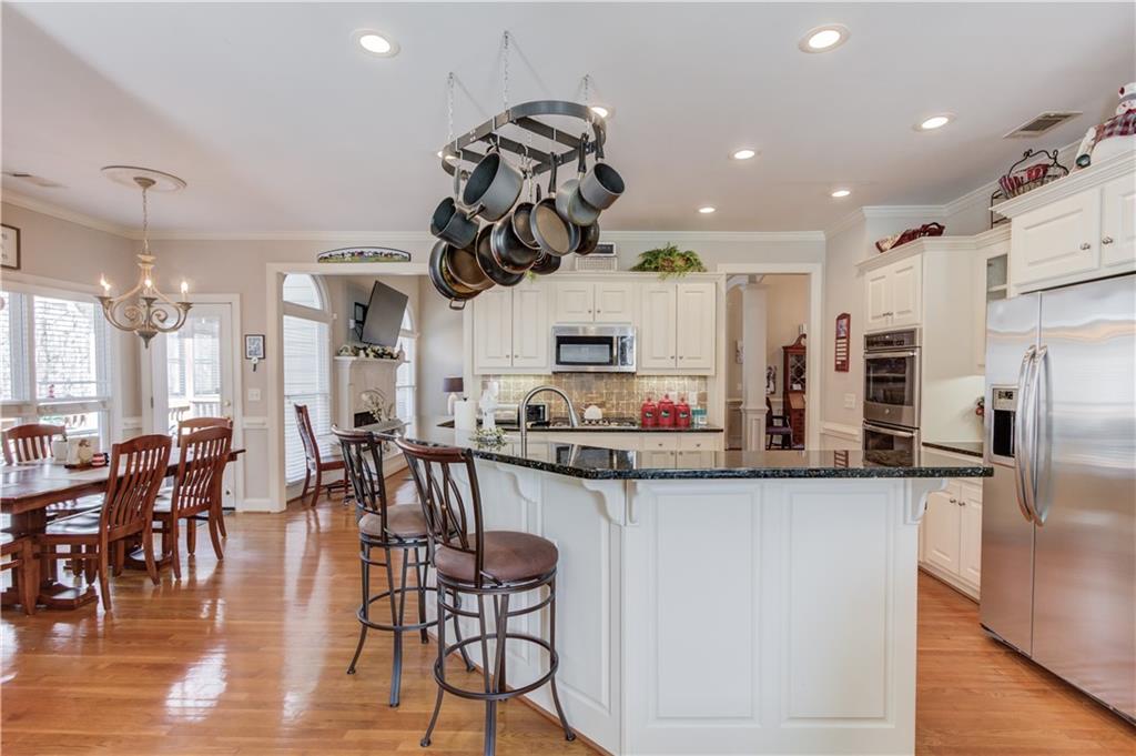 8012 Cypress Point Monroe, GA 30656 - Photo 20 of 67 a kitchen with granite countertop a table chairs microwave and cabinets