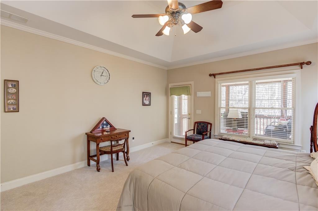 8012 Cypress Point Monroe, GA 30656 - Photo 24 of 67 a spacious bedroom with a bed and a chandelier
