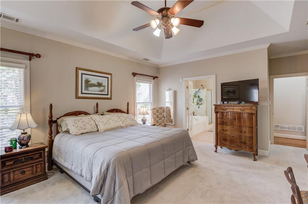 8012 Cypress Point Monroe, GA 30656 - Photo 26 of 67 a bedroom with a large bed a flat tv screen and dresser