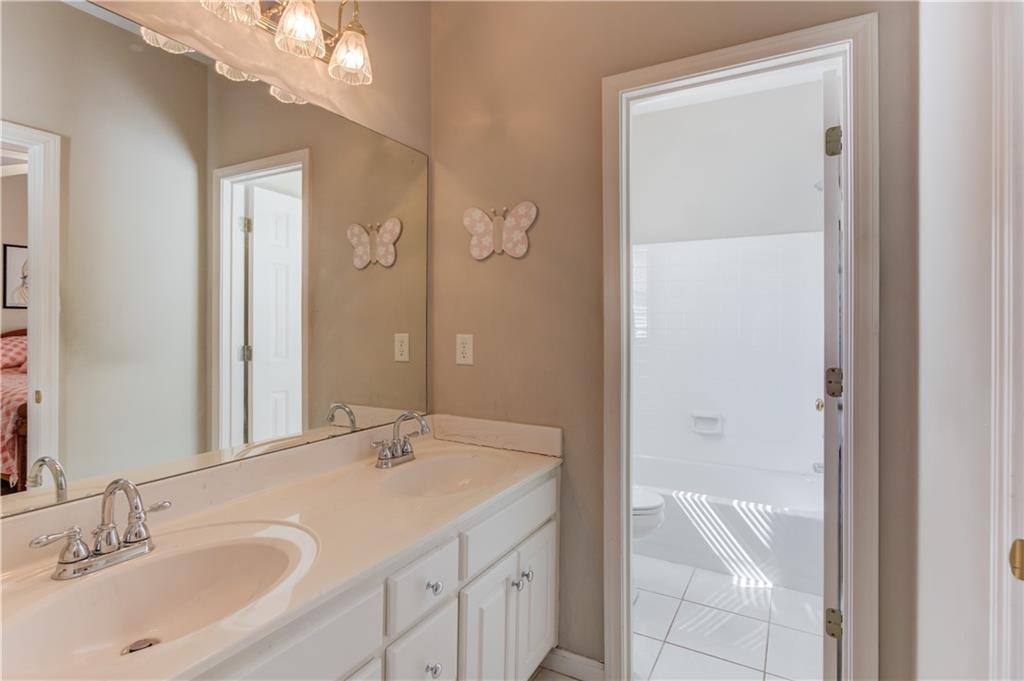 8012 Cypress Point Monroe, GA 30656 - Photo 35 of 67 a bathroom with a granite countertop sink a mirror and a bathtub