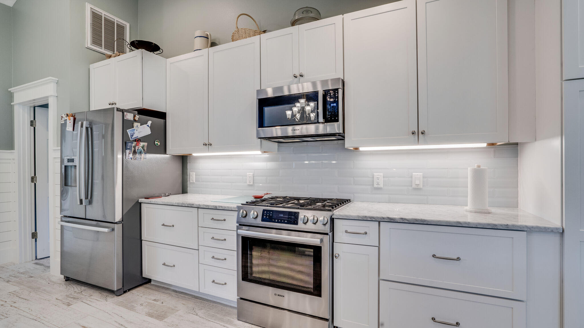 786 Mack Bayou Road Santa Rosa Beach, FL 32459 - Photo 9 of 42 a kitchen with white cabinets and stainless steel appliances