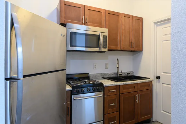 a kitchen with stainless steel appliances granite countertop a refrigerator stove and microwave