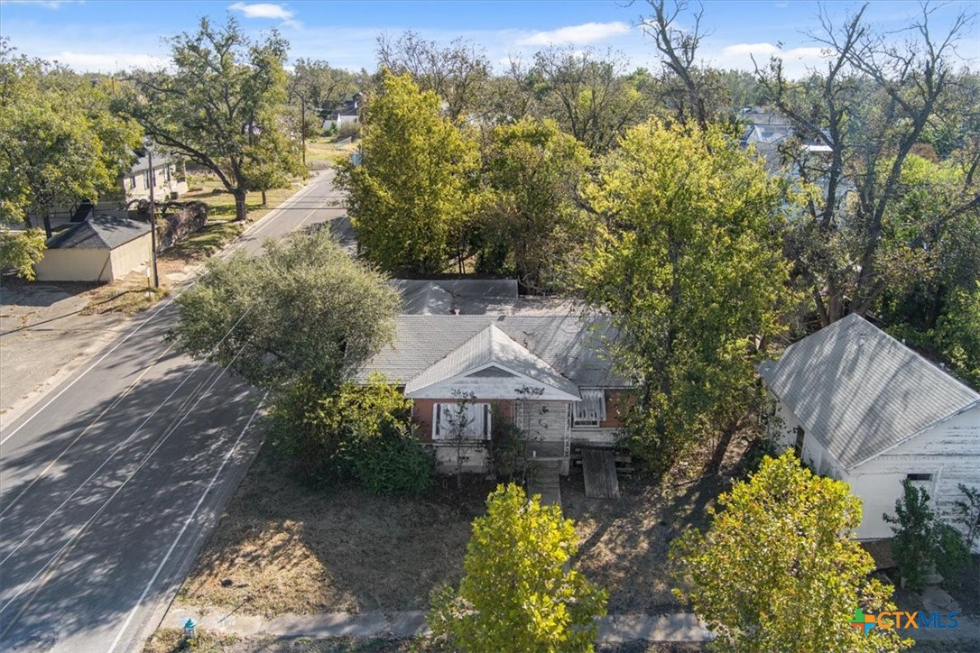 a front view of a house with a yard and fountain in middle