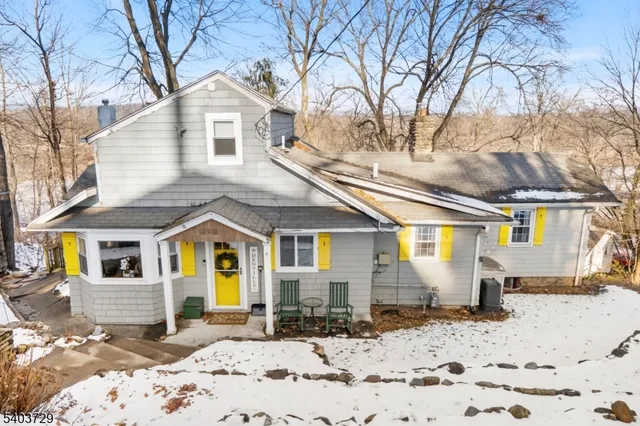 a front view of a house with a yard covered in snow
