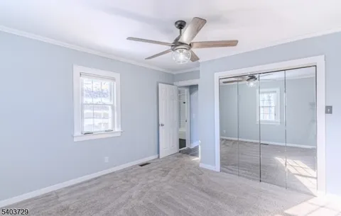 a view of a hallway with wooden floor and cabinet