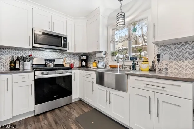 a kitchen with stainless steel appliances granite countertop a refrigerator sink and stove