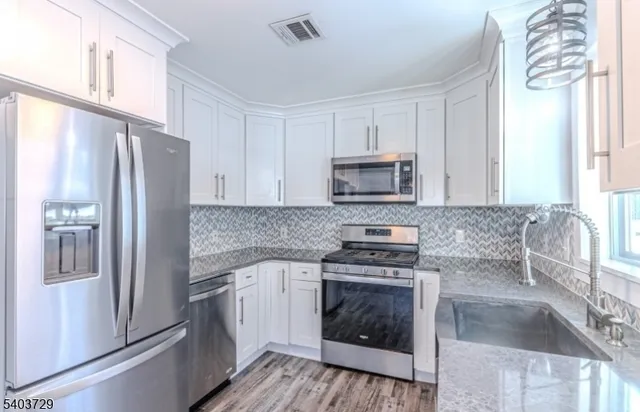 a kitchen with cabinets a sink and appliances
