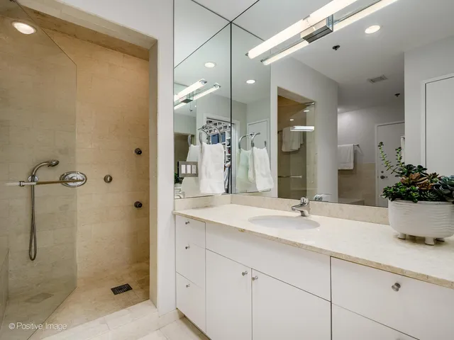 a bathroom with a shower sink and mirror