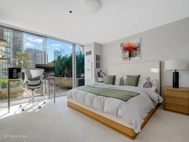 a bedroom with a bed and a large window