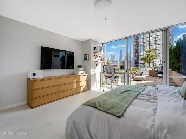 a bedroom with a bed and large windows