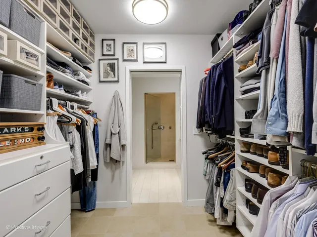 a view of walk in closet with clothes and shoes