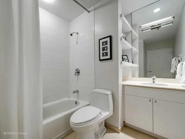 a bathroom with a toilet sink vanity tub and shower