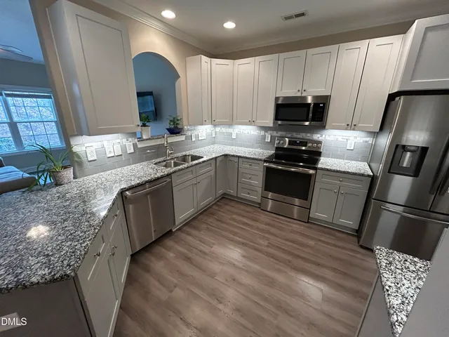 a kitchen with a refrigerator microwave and stove top oven