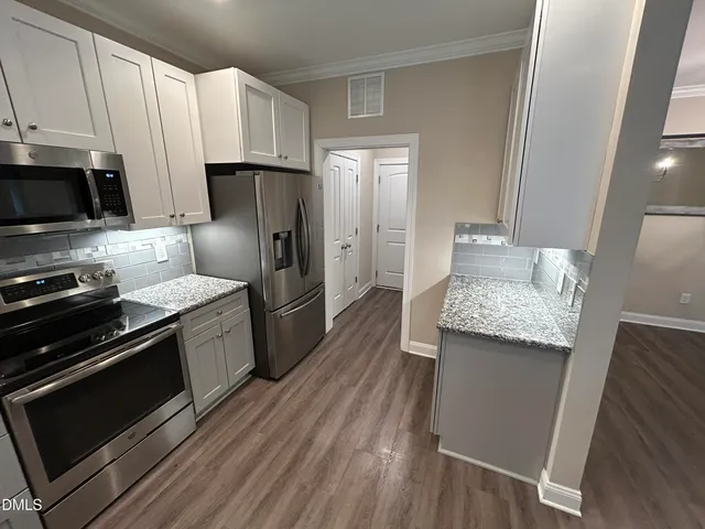a kitchen with stainless steel appliances granite countertop a sink stove and cabinets