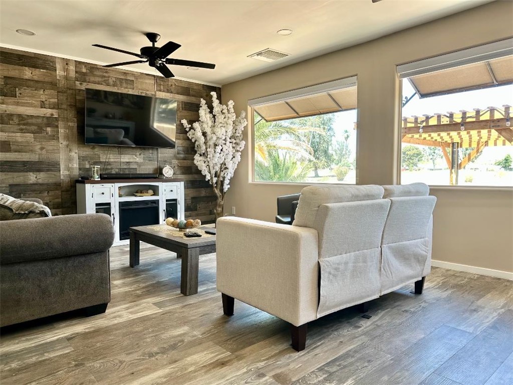 1395 Lause Road Bullhead City, AZ 86442 - Photo 7 of 34 Living area featuring a reclaimed wood accent wall, multiple windows with outdoor pergola views