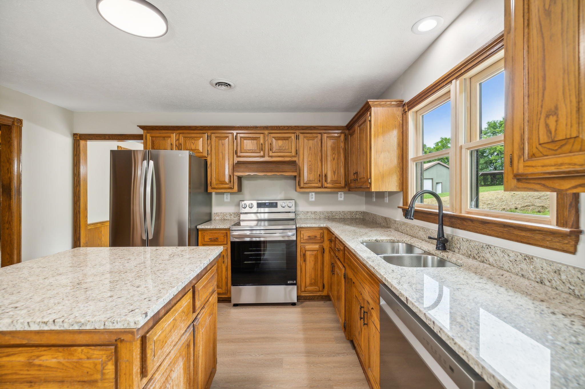 969 Trice Road Lebanon, TN 37087 - Photo 23 of 47 a kitchen with stainless steel appliances granite countertop a sink a stove and a refrigerator
