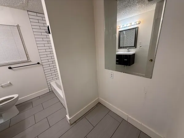 a view of an empty room with wooden floor and closet