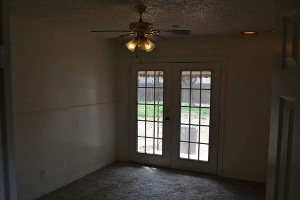 en empty room with ceiling fan and window