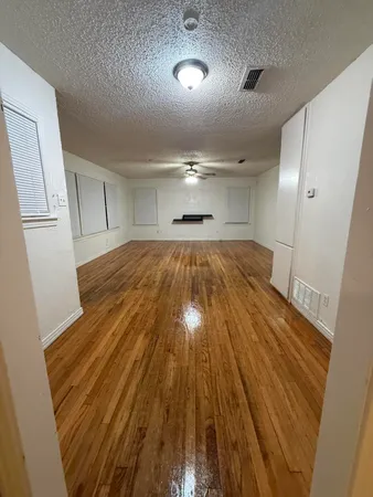 a view of an empty room with wooden floor