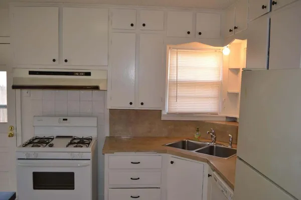 a kitchen with a refrigerator and a stove