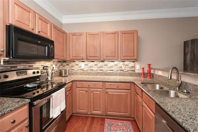 a kitchen with stainless steel appliances granite countertop a stove microwave and sink