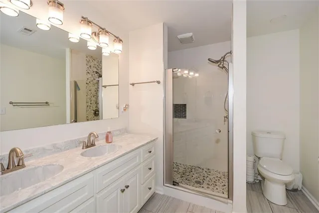 a bathroom with a sink a toilet and shower