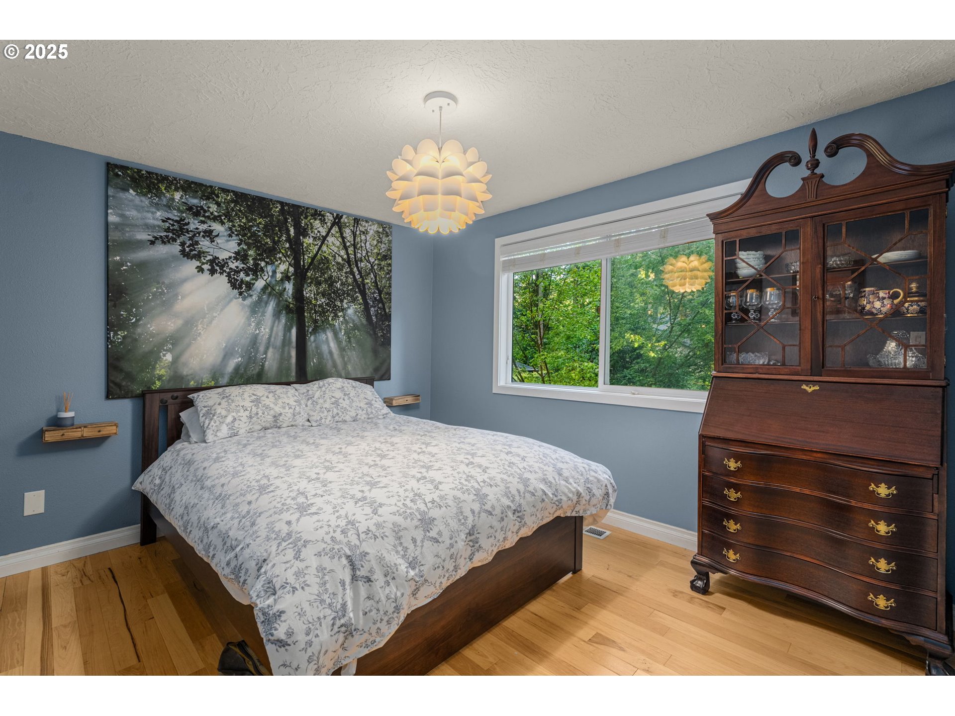 18863 Southwest Indian Springs Road Lake Oswego, OR 97035 - Photo 17 of 33 a bedroom with a bed and a chandelier