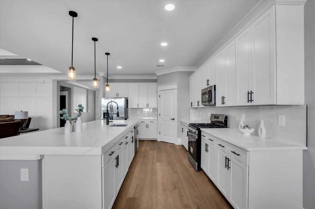 15159 Sea Salt Way Bradenton, FL 34211 - Photo 8 of 55 a kitchen with white cabinets sink and stainless steel appliances