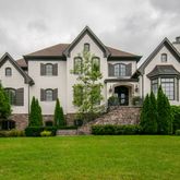 a front view of a house with a garden and plants
