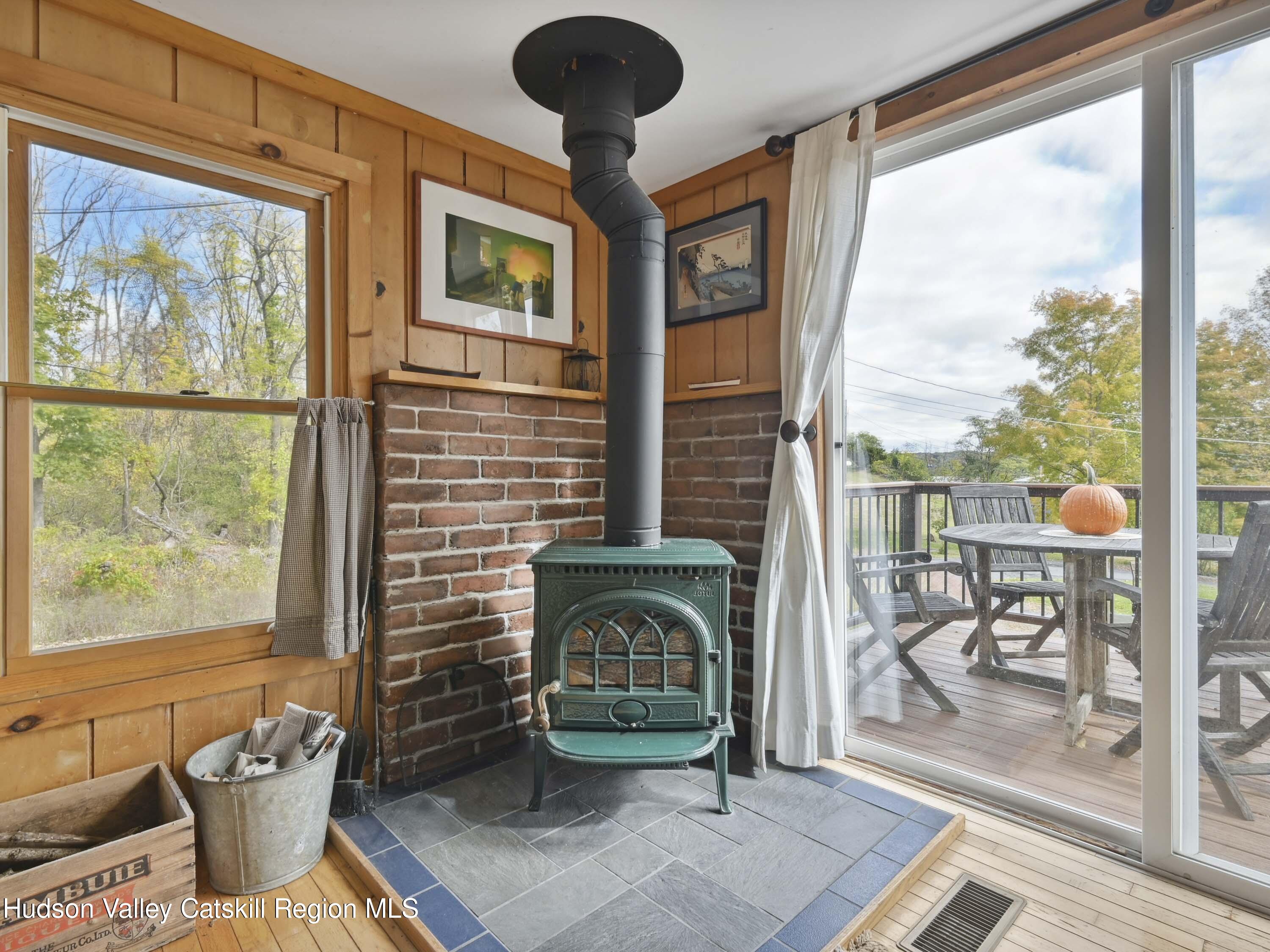 123 Maple Street Catskill, NY 12414 - Photo 9 of 47 a living room with furniture a fireplace and a floor to ceiling window