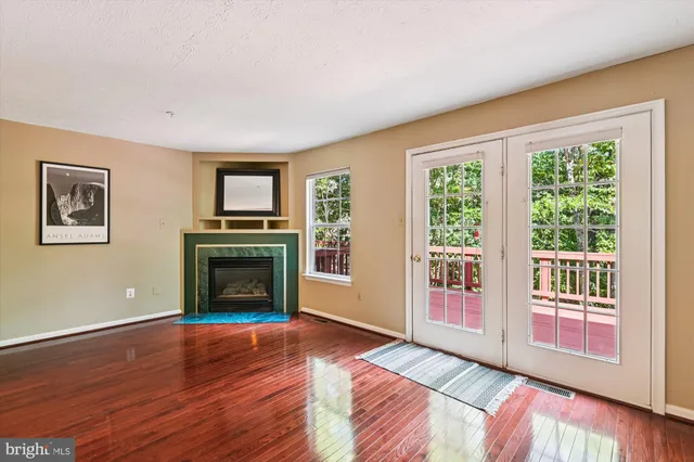 a view of a livingroom with a fireplace wooden floor and window