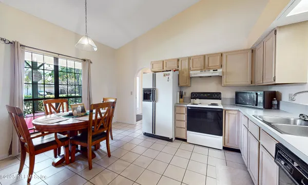a kitchen with stainless steel appliances granite countertop a stove a refrigerator a sink dishwasher with a dining table and chairs