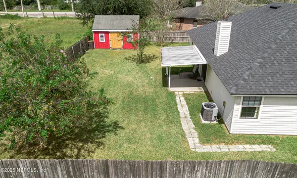 a view of a house with a small yard and wooden fence
