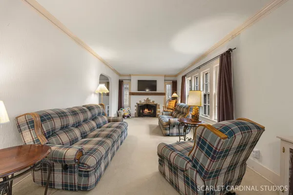 a living room with furniture fireplace and a large window