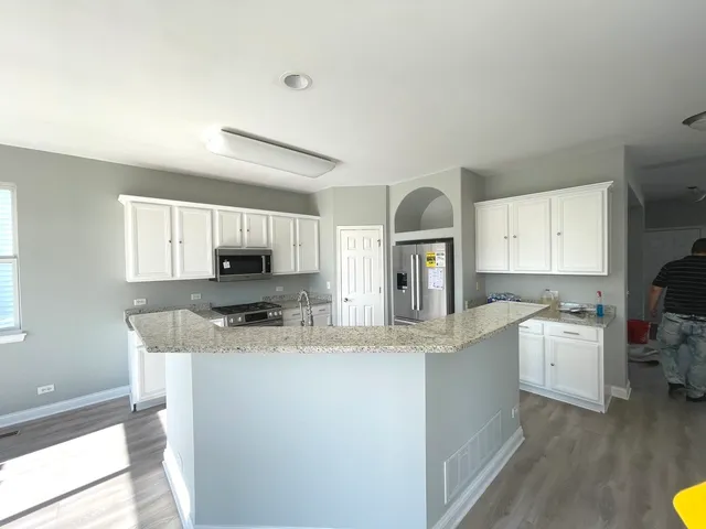 a kitchen with stainless steel appliances granite countertop a sink stove and cabinets