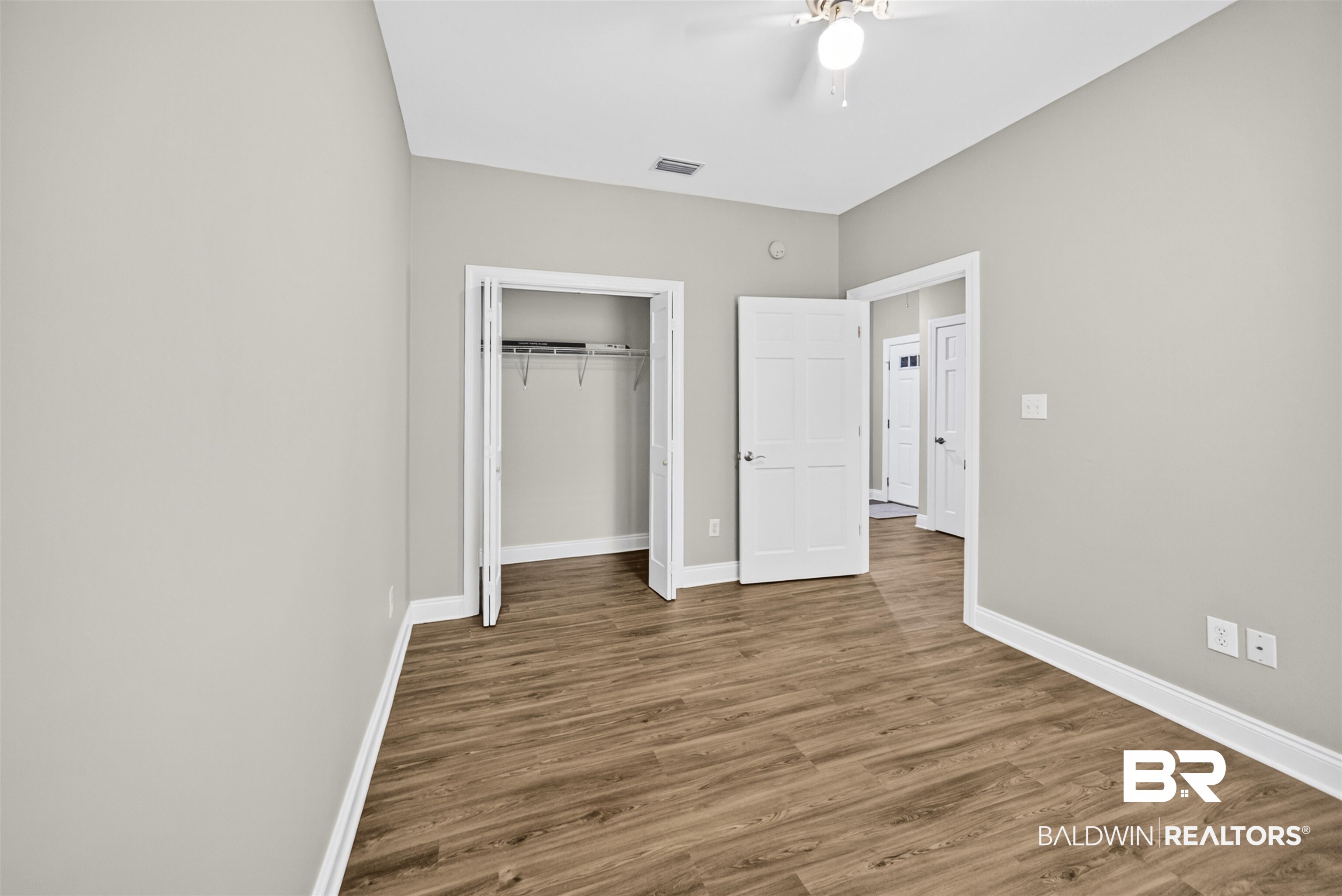 5913 Antoine Road Mobile, AL 36693 - Photo 19 of 33 Interior room featuring wood-finish flooring, light gray wall paint, and white trim
