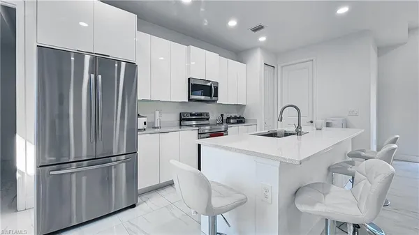 a kitchen with stainless steel appliances a refrigerator sink and microwave