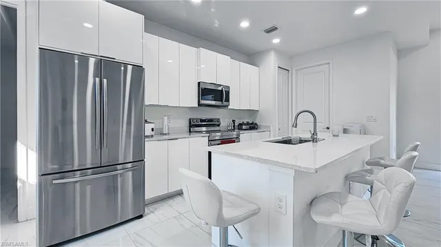 a kitchen with stainless steel appliances a refrigerator sink and microwave